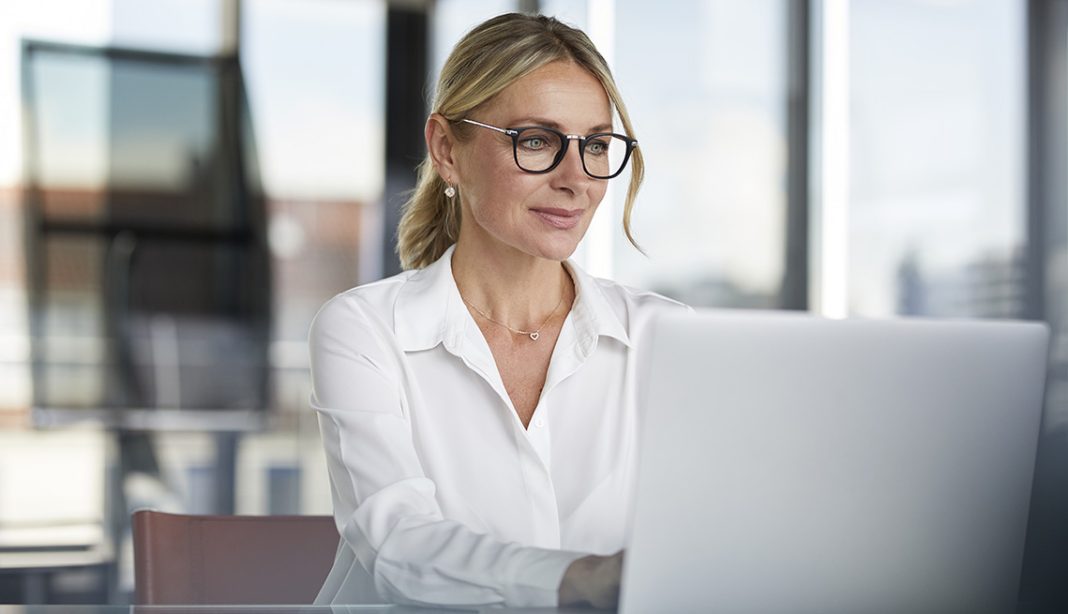 Businesswoman working in office, using laptop