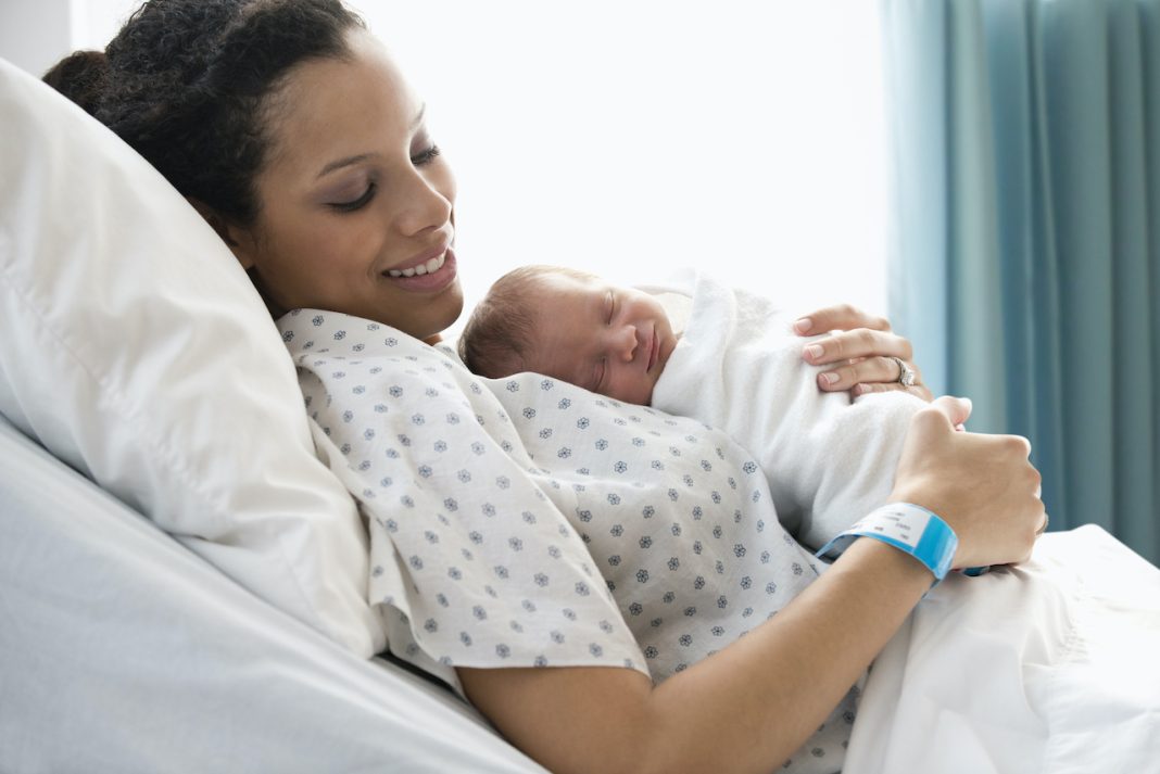 Mixed race mother admiring newborn baby son
