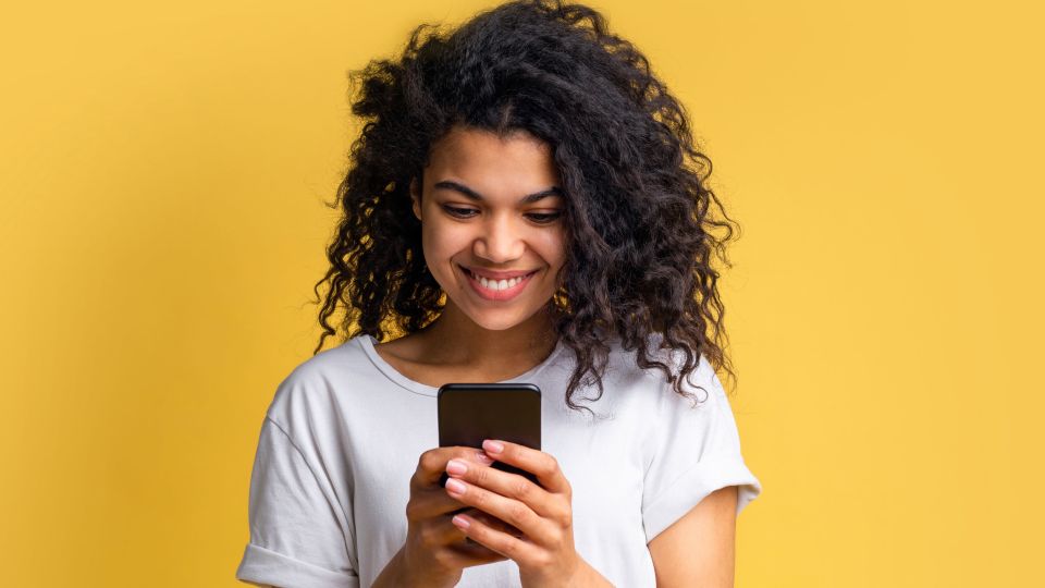 Portrait of attractive young african american girl using mobile phone